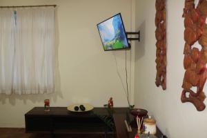 a living room with a tv on the wall at Anfitrioca Apartamento Gloria in Rio de Janeiro
