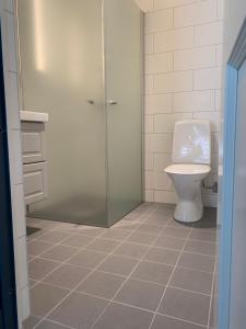 a bathroom with a toilet and a glass shower stall at Orrvägen in Torshälla