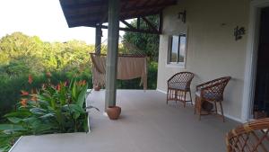 um alpendre com 2 cadeiras e uma rede de descanso em Terraço Guaramiranga em Mulungu