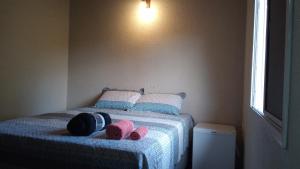 um quarto com uma cama com dois chinelos cor-de-rosa em Terraço Guaramiranga em Mulungu