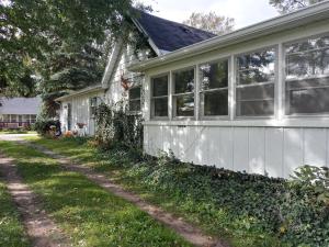 Casa blanca con ventanas y entrada en Entire Lake Huron sunrise family home with 160 feet of private Beach, en Keewahdin