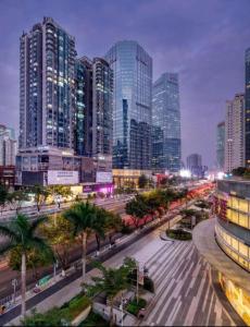 a city with tall buildings and a street with palm trees at Guangzhou Laixizhou Pazhou Aparthotel - Enjoy free Shuttle Bus & Guidance Service in Canton Fair in Guangzhou