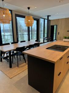 a dining room with a table and chairs and windows at Luxury Holiday Villa Lake Pavillion in Turenki