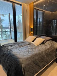 a large bed in a bedroom with a large window at Luxury Holiday Villa Lake Pavillion in Turenki