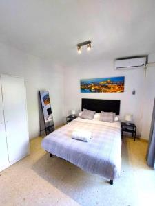 ein Schlafzimmer mit einem Bett und einem Gemälde an der Wand in der Unterkunft Fray Isidoro Apartment in Sevilla