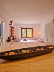 a room with a bed and a tray of food on a table at Casa Studio Migjorn, immersi nel verde a due passi dal mare in Es Calo