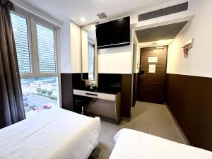 新加坡的住宿－The Snooze Hotel at Bugis，酒店客房设有两张床和电视。