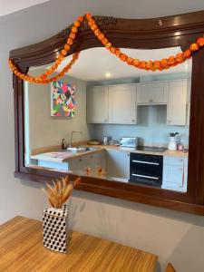 a kitchen with an orange garland above a counter at Beautiful Retro Flat above Pub. in Shepton Mallet