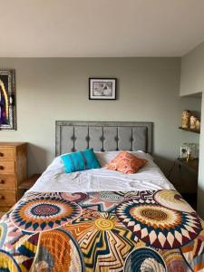 a bedroom with a bed with a quilt on it at Beautiful Retro Flat above Pub. in Shepton Mallet