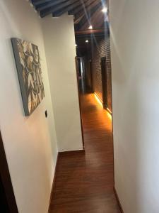 un pasillo que conduce a una habitación con paredes blancas y suelo de madera. en Hotel El Bricial, en Soto de Cangas