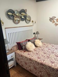 a bedroom with a bed with two hats on the wall at Hotel El Bricial in Soto de Cangas