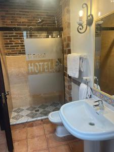 een badkamer met een toilet en een wastafel bij Hotel El Bricial in Soto de Cangas