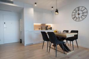 a kitchen and dining room with a table and chairs at Apartament Premium Sea View PINEA 712 in Pobierowo
