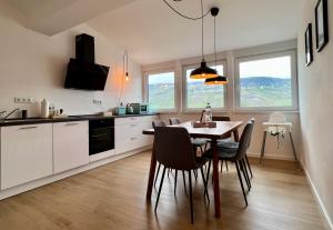 een keuken met een tafel en stoelen in een kamer bij VonMos Loft Apartment in Bernkastel-Kues