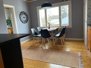 a dining room with a table and chairs and a clock at BySannah in Porvoo