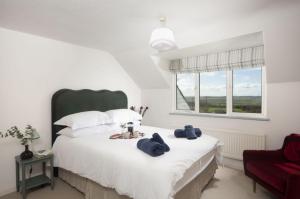 a bedroom with a large white bed and a red chair at Westaway House in Port Isaac +81 photos