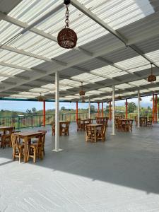 einen Pavillon mit Holztischen und -stühlen auf einer Terrasse in der Unterkunft Villa Jair Hotel in Filandia