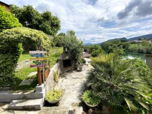 a garden with plants and a sign next to a river at @LaCasettasulFiume in Sarnico +97 photos