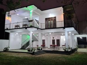 una grande casa bianca con balcone e tavoli di Jungle Lodge a Udawalawe