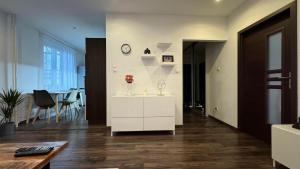 a living room with a white cabinet with a clock on a wall at Milde's apartment near the city center - Hospodarska street in Trnava