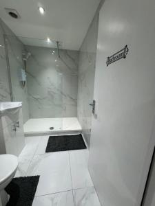 a white bathroom with a shower and a toilet at Fully furnished 1 Bedroom flat in London
