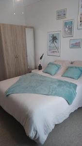 1 dormitorio con 1 cama grande con almohadas azules en Appartement une chambre avec balcon, en Chambly