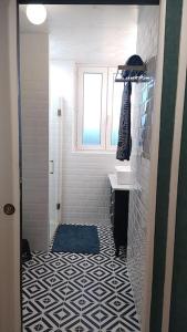 y baño con suelo de baldosa blanco y negro. en Appartement une chambre avec balcon, en Chambly