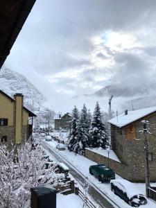 una ciudad cubierta de nieve con coches aparcados en una calle en El Dúplex de Espot, en Espot