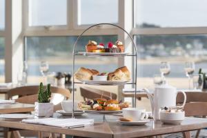 a table with a plate of pastries and desserts on a stand at Harbour Hotel Padstow in Padstow