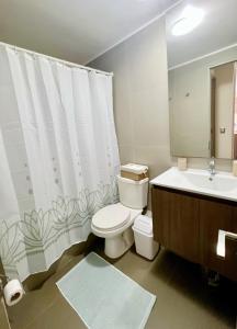 a bathroom with a toilet and a sink at Vista Increíble en Laguna Del Mar piso 13 in La Serena +2 photos