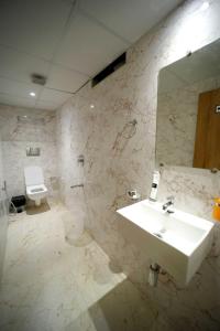 La salle de bains est pourvue d'un lavabo, de toilettes et d'un miroir. dans l'établissement CABINSTAY-AIRPORT, à Mumbai