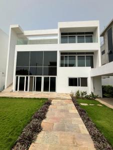 een groot wit gebouw met een pad ervoor bij Luxe villa in Cotonou