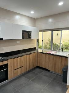 eine Küche mit Holzschränken und einer Mikrowelle in der Unterkunft Luxe villa in Cotonou