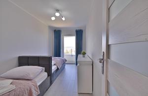 een slaapkamer met 2 bedden en een raam bij Apartamenty Bryza - Sun Towers in Świnoujście