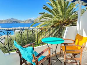 balcón con sillas, mesa y vistas al océano en Patras Apartments, en Fourni Ikarias