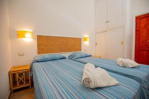 two beds in a bedroom with towels on them at Affitti Brevi Toscana - Ospitalità a P. S. Stefano in Porto Santo Stefano