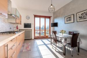 a kitchen with a table and some chairs and a table and a window at San Luigi Apartment 3.0 in Beinasco