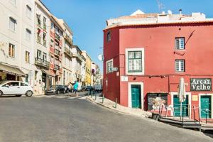 リスボンにあるParaíso Alfamaの赤い建物と人々が歩く道
