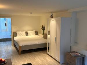a bedroom with a bed with white sheets and a cabinet at Tulip House Luxury Apartment - Top Location - Rijksmuseum - Leidseplein AMSTERDAM Central 120 m2 ALL Private with kitchen in Amsterdam