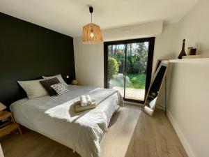 un dormitorio con una cama con un animal de peluche en Villa Patio à 800 m de la plage, en Seignosse