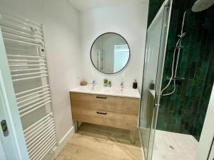 a bathroom with a sink and a shower with a mirror at Villa Patio à 800 m de la plage in Seignosse