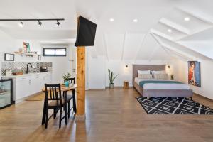 1 dormitorio con cama, mesa y cocina en Valley Suites, en Luzit