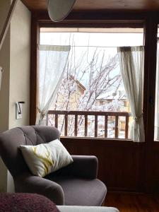 uma sala de estar com uma cadeira e uma janela em Apartamento Deluxe Espot em Espot