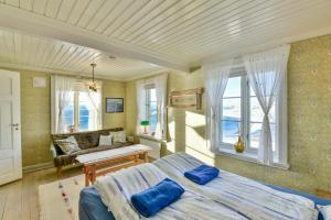 a bedroom with a bed and a couch and windows at Kongsfjord Arctic Lodge in Kongsfjord