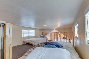 a bedroom with two beds and a staircase at Quiet Lake Almanor Cabin, Steps to Fishing in Lake Almanor