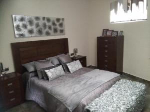a bedroom with a bed and a dresser at Rural Villa Garcia Molina Baza in Baza