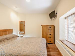 ein Schlafzimmer mit einem Bett, einer Kommode und einem TV in der Unterkunft 1 Bed in Ross-on-Wye 49910 in Walford
