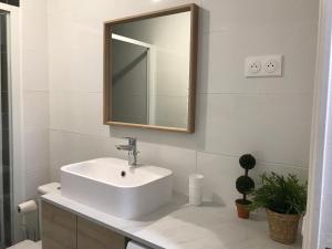 a bathroom with a white sink and a mirror at Une jolie vue - Appt 2 pièces Vue mer Balcon sud in Wimereux +17 photos