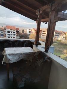 a table and chairs on a balcony with a view at Удобство in Petrich