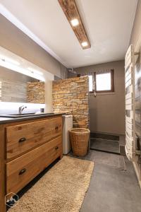 a bathroom with a sink and a brick wall at Gîte Le Cembro 6 personnes in Termignon